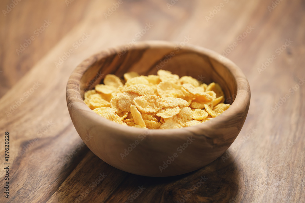 corn flakes in wood bowl closeup corn flakes in wood bowl closeup