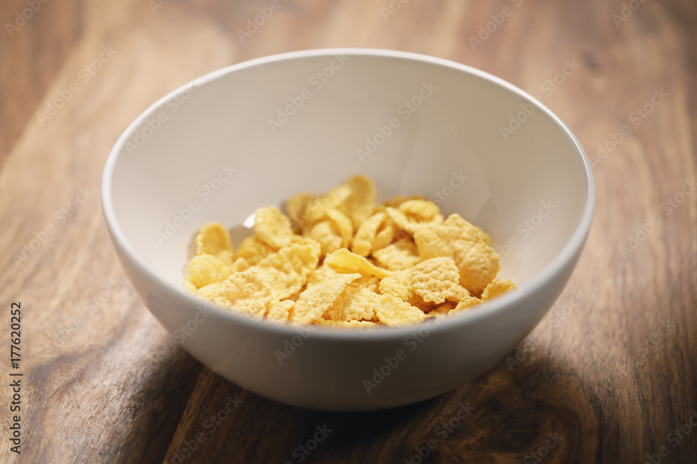 corn flakes in white bowl on table closeup corn flakes in white bowl on table closeup