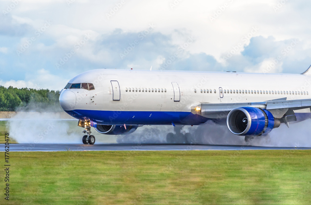 The airplane with the reversed engine on the wet runway. The airplane with the reversed engine on the wet runway.