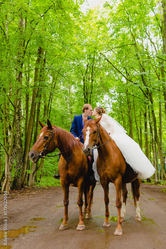 Beautiful newlyweds riding two horses Beautiful newlyweds riding two horses