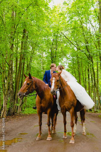 Beautiful newlyweds riding two horses © meatbull