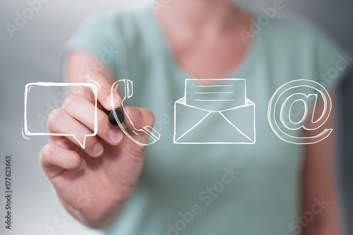 Businesswoman drawing manuscript contact icon with a pen