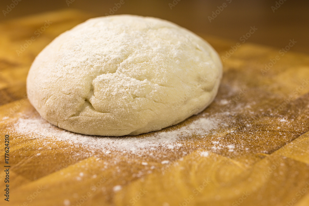 ball of pizza dough with dusting of flour