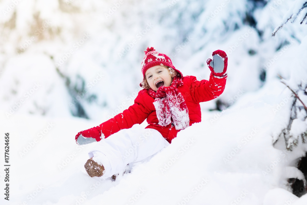 Child playing with snow in winter.Boy in snowy park.