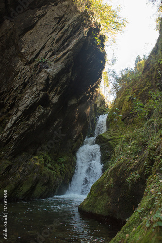 Small hidden waterfall in the forest in the cleft of the rock
