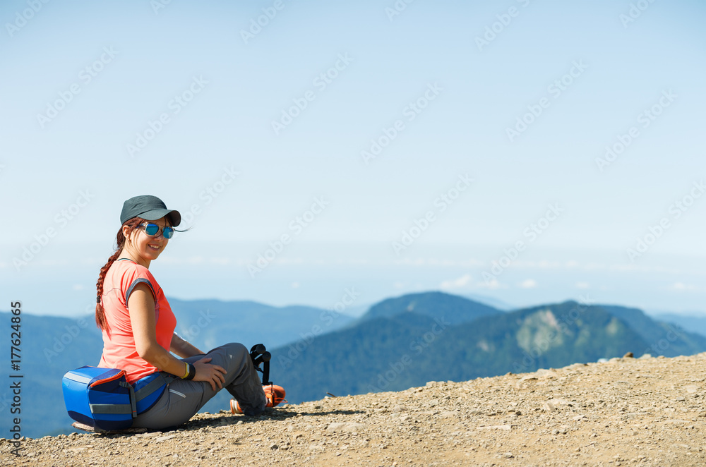 Photo of smiling girl sitting on edge of hill