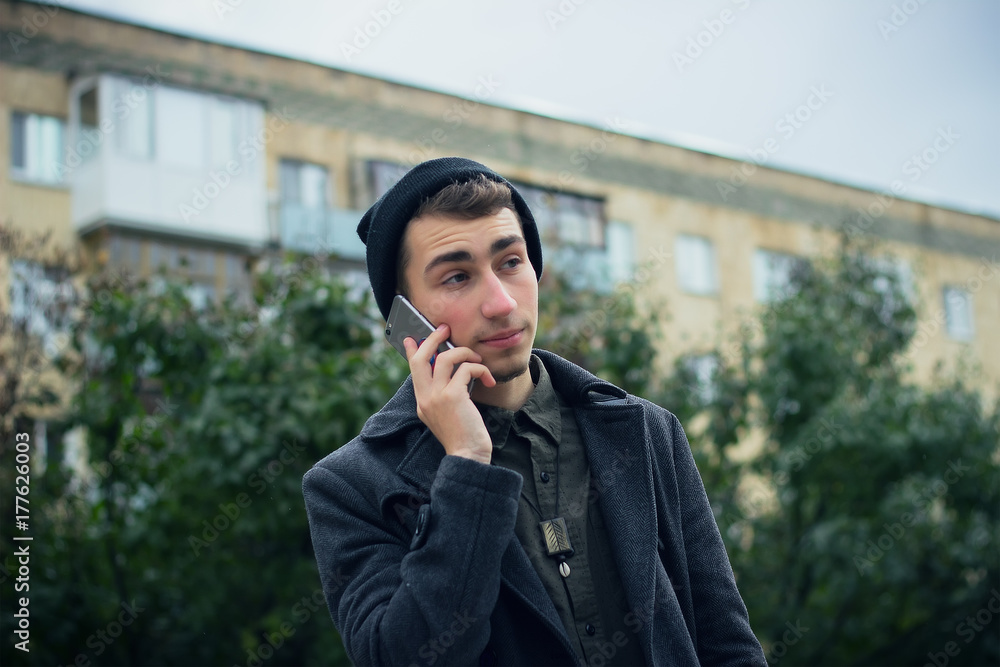 Young man using mobile phone in the city. Hipster and student lifestyle. Young man using mobile phone in the city. Hipster and student lifestyle.
