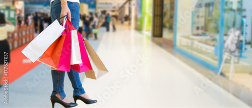 Female walks hands holding shopping bags and credit card in the mall
