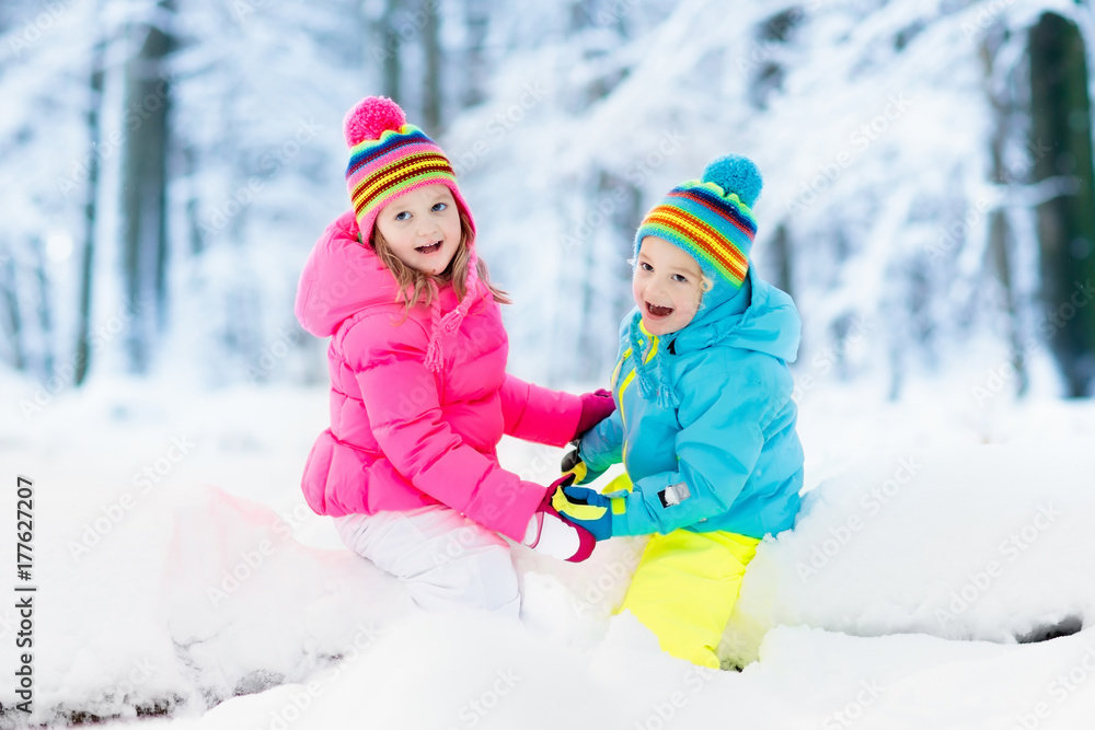 Kids playing in snow. Children play outdoors in winter snowfall. Kids playing in snow. Children play outdoors in winter snowfall.