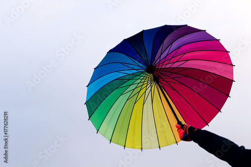 Umbrella in hand against sky background