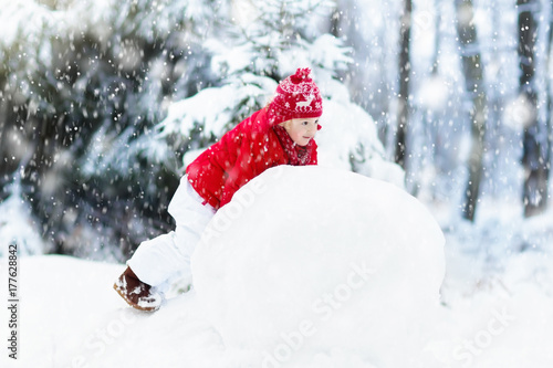 Kids building snowman. Children in snow. Winter fun. © famveldman