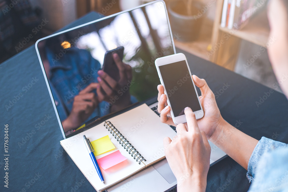 Woman hand using a white mobile phone on a blank screen. Woman hand using a white mobile phone on a blank screen.