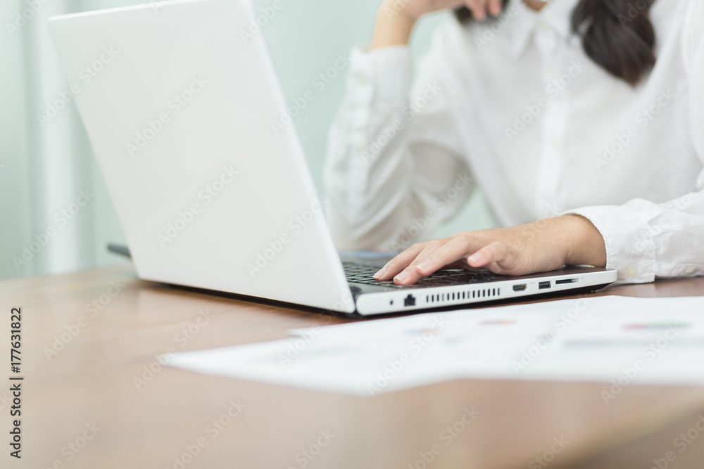 Young business woman working on laptop in office. Young business woman working on laptop in office.
