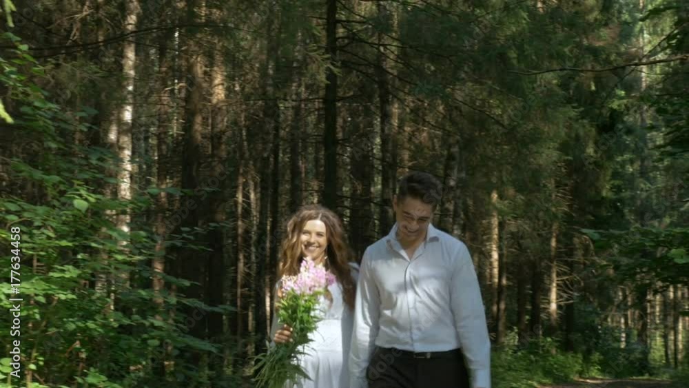 Beautiful young couple in white clothes walking in the woods. Beautiful young couple in white clothes walking in the woods.
