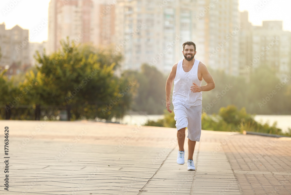 Handsome young man jogging on street