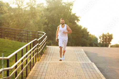 Handsome young man jogging in park