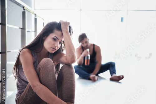 Sad woman and drunk man sit...