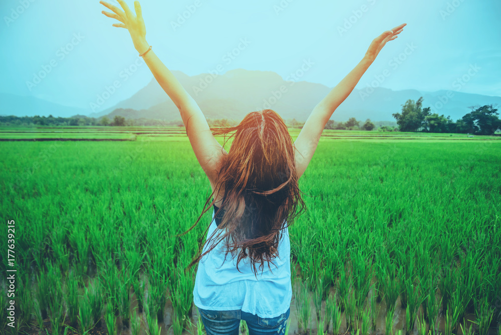 Asian women travel relax in the holiday. Stand up to receive rain. In the rice field in the countryside Asian women travel relax in the holiday. Stand up to receive rain. In the rice field in the countryside