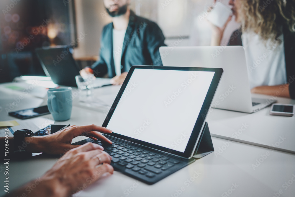 Young woman using electronic tablet with keyboard dock station at night modern office loft.Teamwork concept.Blurred background.Horizontal mockup. Young woman using electronic tablet with keyboard dock station at night modern office loft.Teamwork concept.Blurred background.Horizontal mockup.