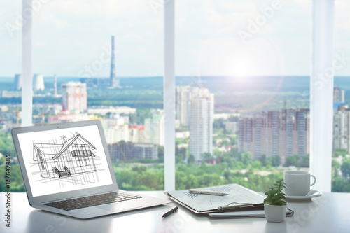  Modern technology concept. Laptop on table and cityscape view through window