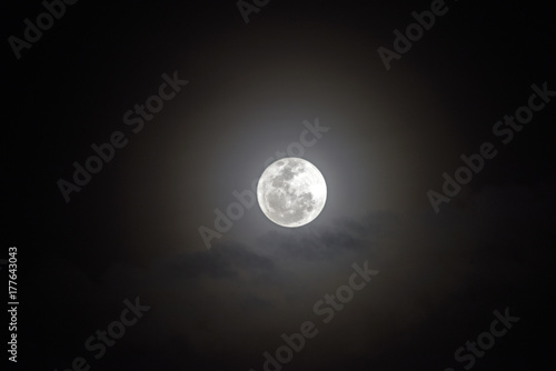 Full moon with bright halo in the dark sky