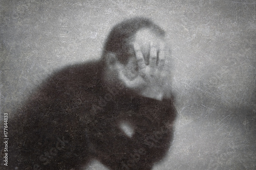 Canvas Print Depression. Broken man behind a dusty scratched glass.