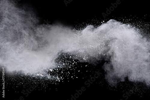 Freeze motion of white powder explosions isolated on black background