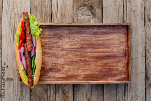 Oktoberfest. German hot dog with grilled sausages, onions and vegetables. French roll with grilled sausages from lamb. photo