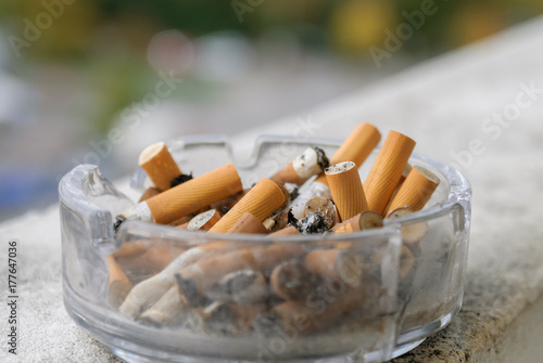 Cigarette butts in astray closeup photo