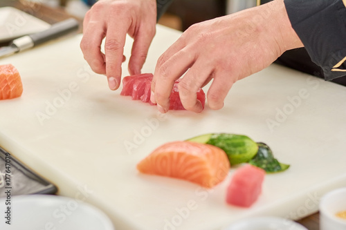 Chef sliced raw tuna fillet. The process of sushi making at professional kitchen. Cook at work, kitchen.