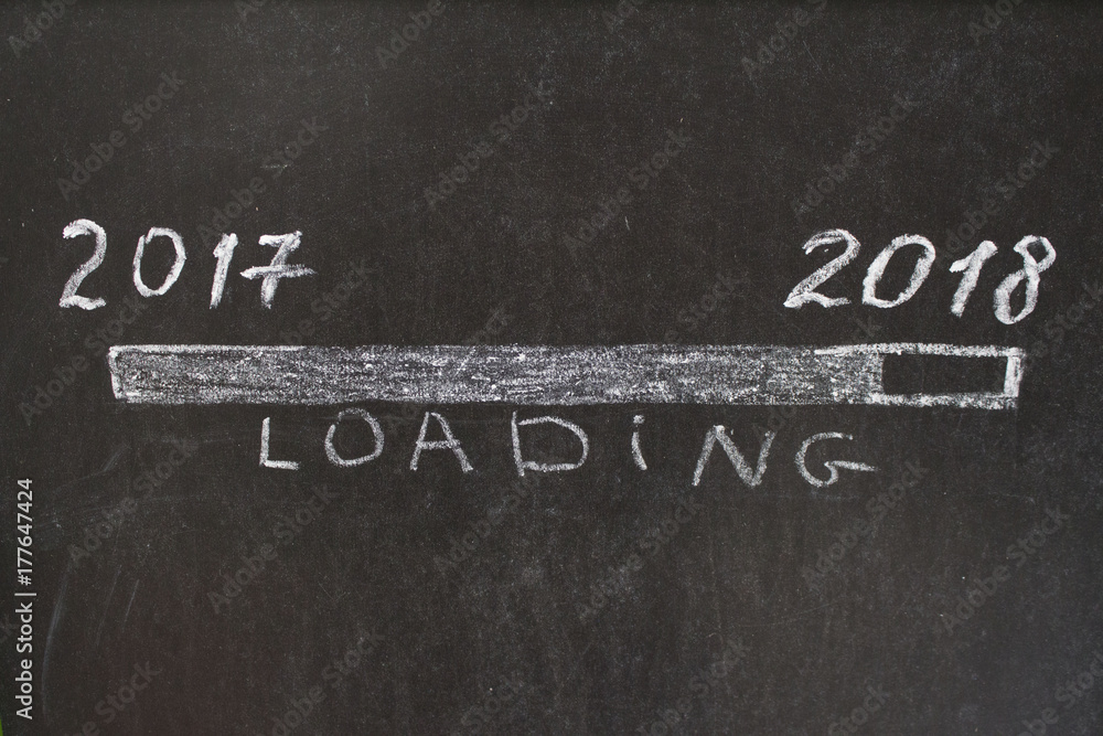 Fototapeta premium 2017 year on the left and 2018 year on the right with sign loading. Hand drawing with chalk on blackboard. Conceptual image. 