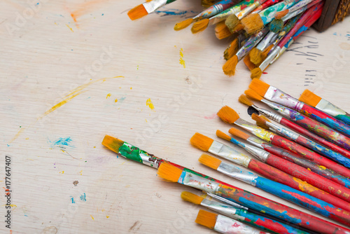 paintbrushes and basket on a wood table