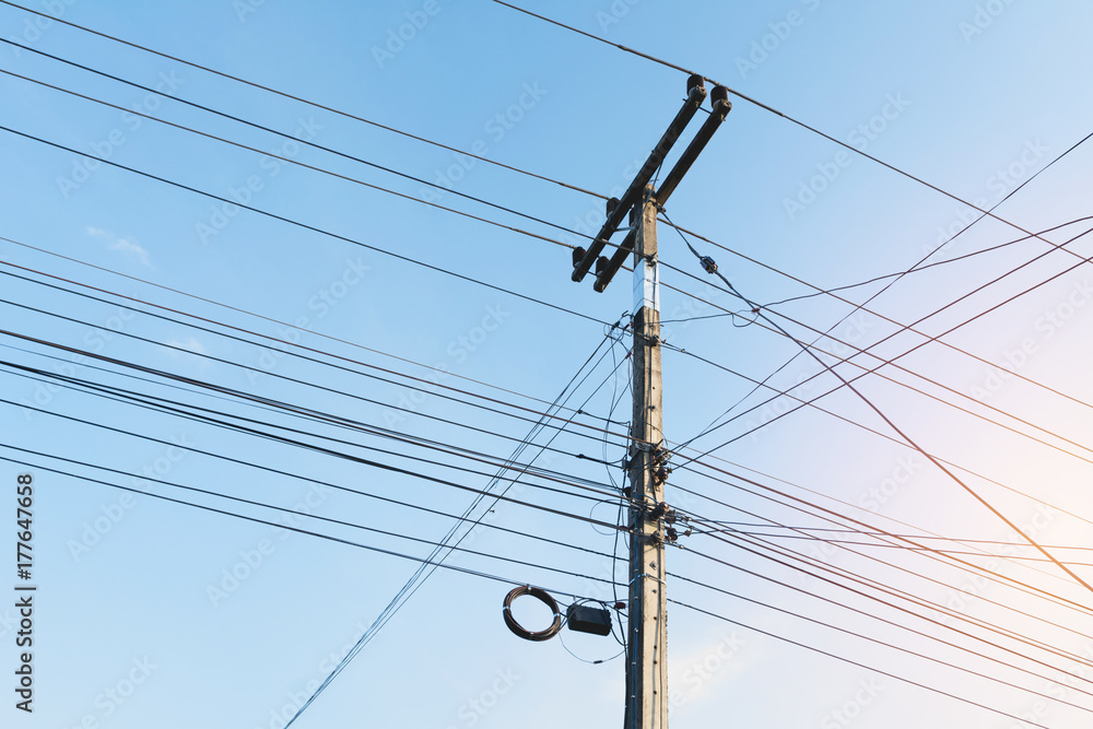 The electric pole with black wire cable and clear blue sky. Concrete electricity pole on blue sky background.