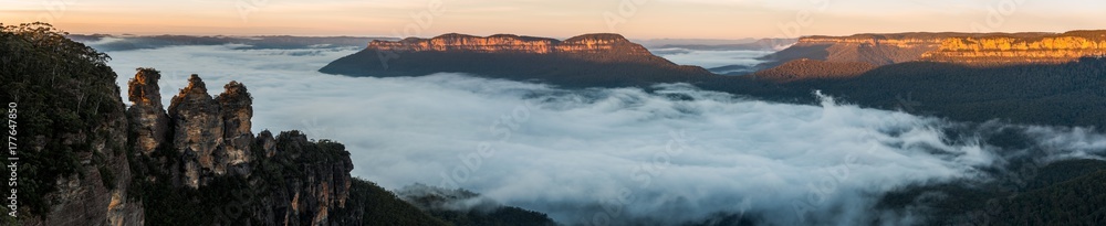 The Three Sisters and Mount Solitary with dawn fog. Katoomba, N.S.W. Australia.