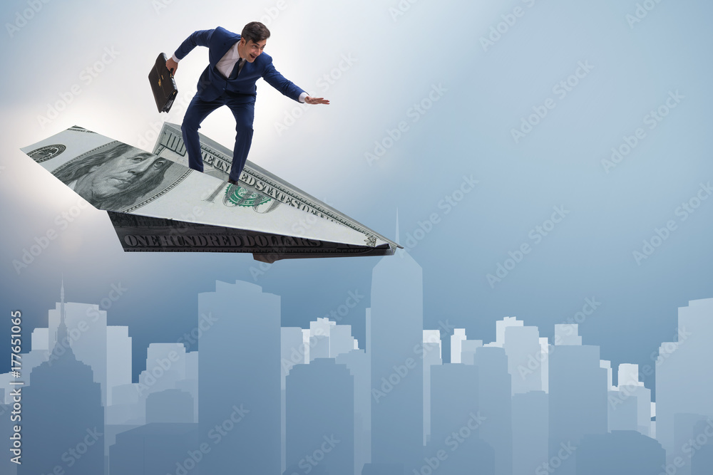 Businessman flying on paper plane in business concept Businessman flying on paper plane in business concept