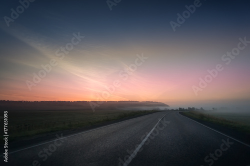 summer rural landscape with blue and red sky  fog and the road. sunrise