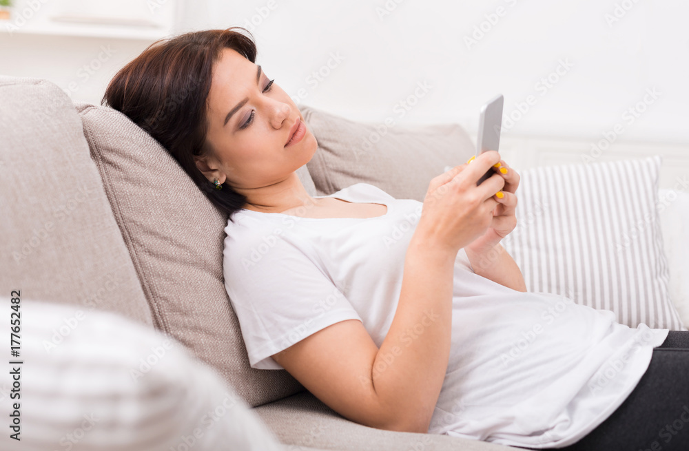 Pensive young girl texting on smartphone Pensive young girl texting on smartphone