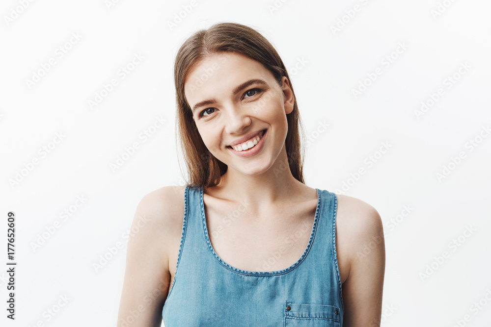 Close up isolated portrait of cheerful charming young american student girl with dark hair and brown eyes smiling in camera showing teeth, being happy and relaxed. Positive emotions and attitude. Close up isolated portrait of cheerful charming young american student girl with dark hair and brown eyes smiling in camera showing teeth, being happy and relaxed. Positive emotions and attitude.
