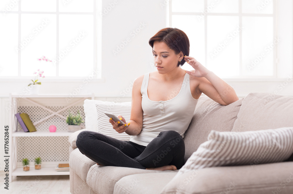 Young pensive woman messaging online with smartphone Young pensive woman messaging online with smartphone