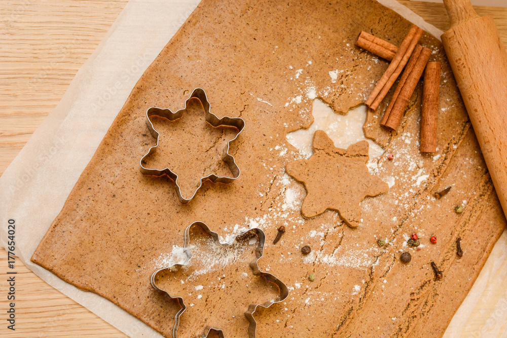 Homemade gingerbread cookies dough, cinnamon and bakery tools. New year, Christmas, winter and cooking background with copy space Homemade gingerbread cookies dough, cinnamon and bakery tools. New year, Christmas, winter and cooking background with copy space