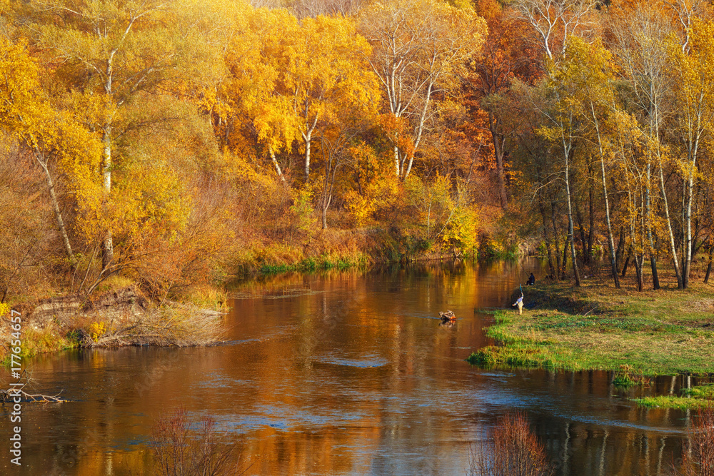 Autumn river landscape with fishing unknown persons