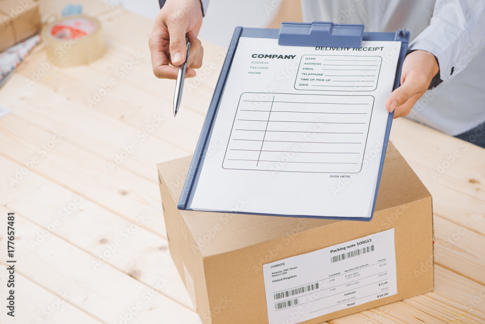 Obraz premium Delivery man presenting receiving form in post office