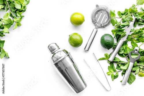 Make mojito cocktail with lime and peppermint in shaker. White background top view copyspace