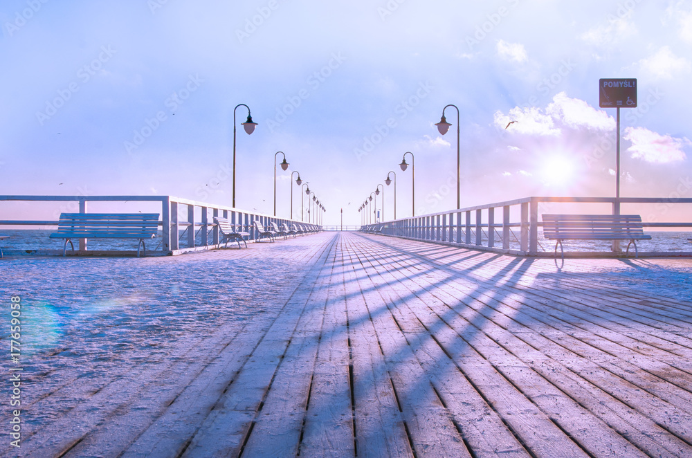 Obraz premium Drewniane molo, pokryte świeżą warstwą śniegu, zimowy poranek. 