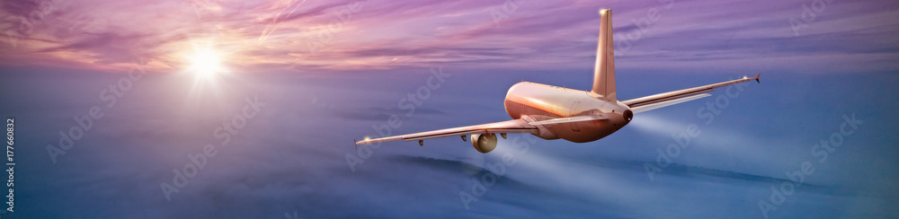 Naklejka premium Komercyjny samolot latający nad chmurami