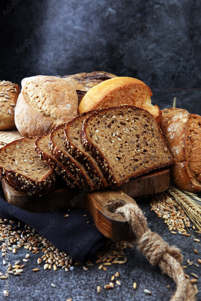 Sliced rye bread on cutting board. Whole grain rye bread and rolls with seeds. Sliced rye bread on cutting board. Whole grain rye bread and rolls with seeds.