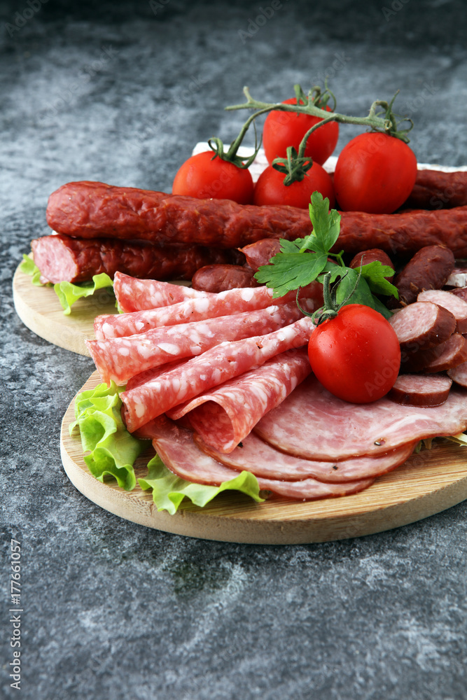 Food tray with delicious salami, pieces of sliced ham, sausage, tomatoes, salad and vegetable - Meat platter with selection - Cutting sausage and cured meat Food tray with delicious salami, pieces of sliced ham, sausage, tomatoes, salad and vegetable - Meat platter with selection - Cutting sausage and cured meat