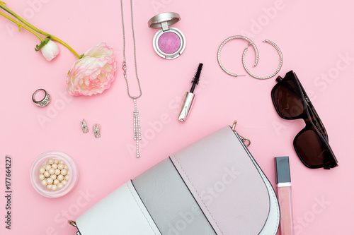 Fashion accessories, cosmetics and handback on a pink background. Flat lay photo