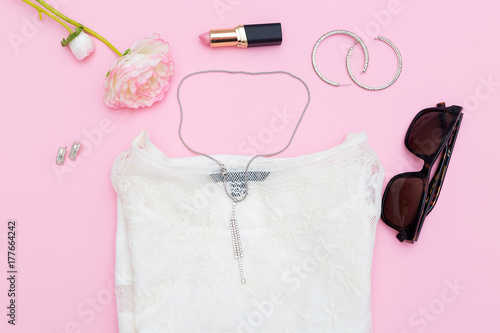 Women's accessories and jewelry on a pink background. Flat lay