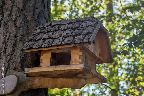 Wooden house for birds with original roof close-up.